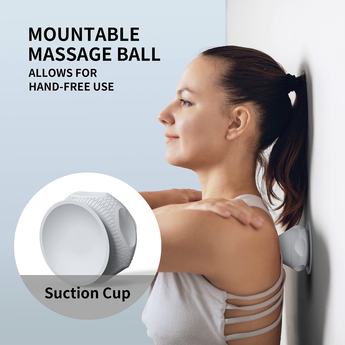Grey PROIRON suction cup massage ball positioned against a smooth wall for shoulder self-massage
